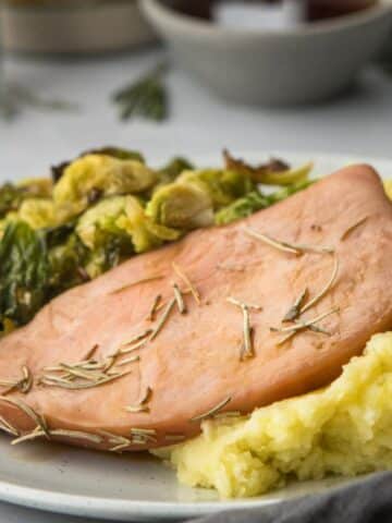 square image of ham and veggies on the side
