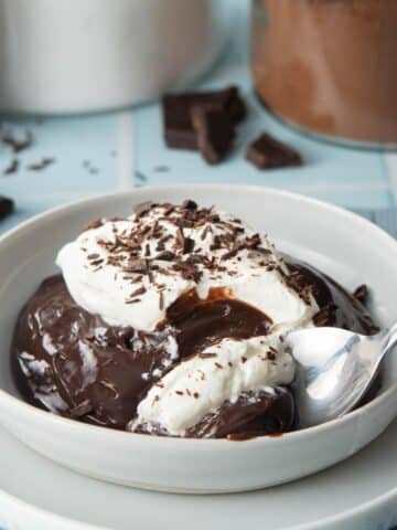 spoonful of chocolate pudding with whipped cream and chocolate shavings